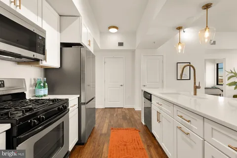a kitchen with kitchen island a sink stainless steel appliances and cabinets