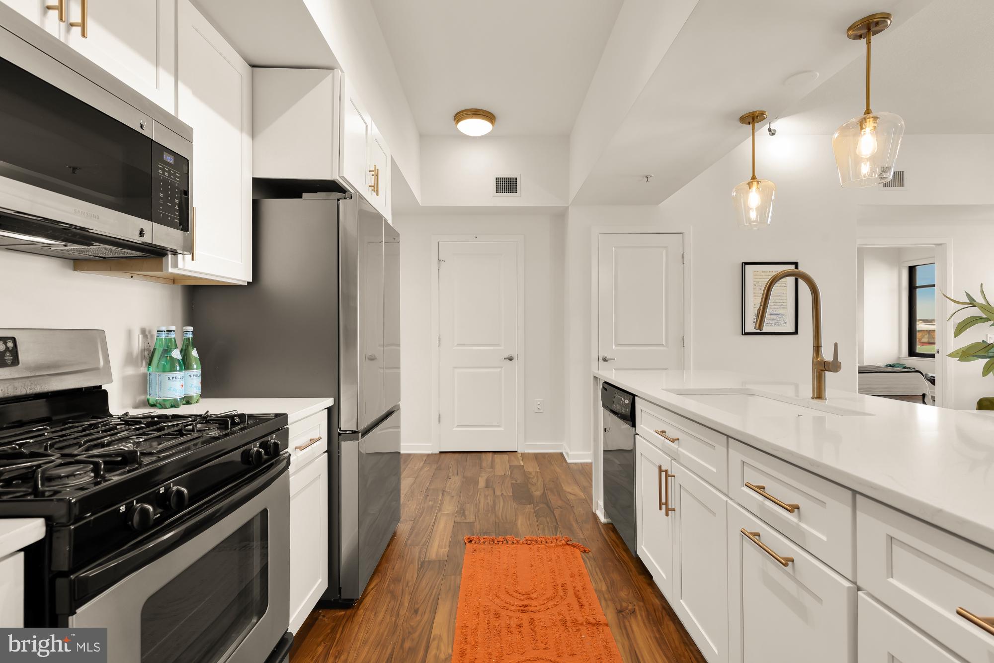 475 K Street Northwest, Unit 1126 Washington, DC 20001 - Photo 10 of 51 a kitchen with kitchen island a sink stainless steel appliances and cabinets