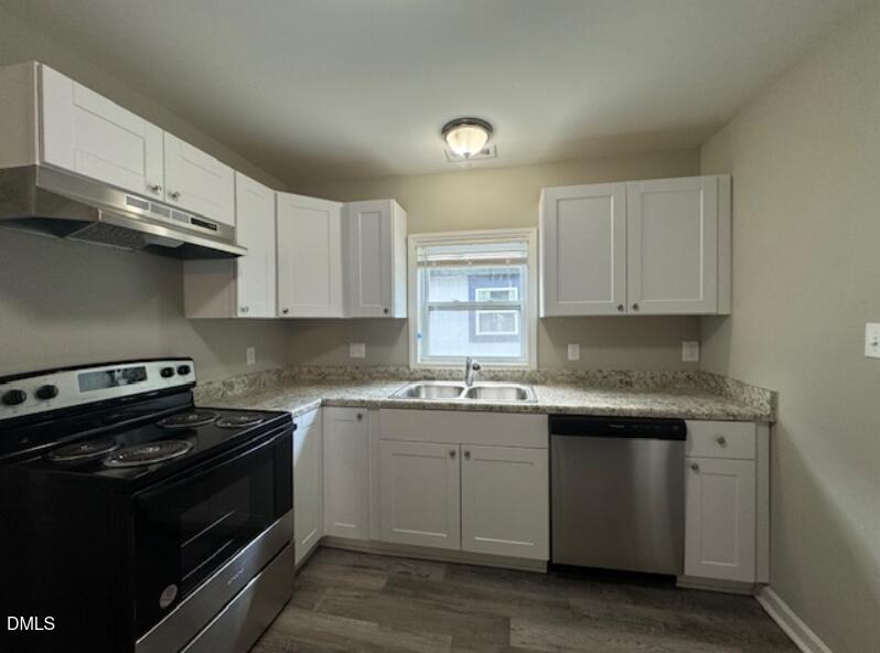 403 Spring Court Henderson, NC 27536 - Photo 4 of 7 a kitchen with stainless steel appliances granite countertop a stove a sink and a microwave