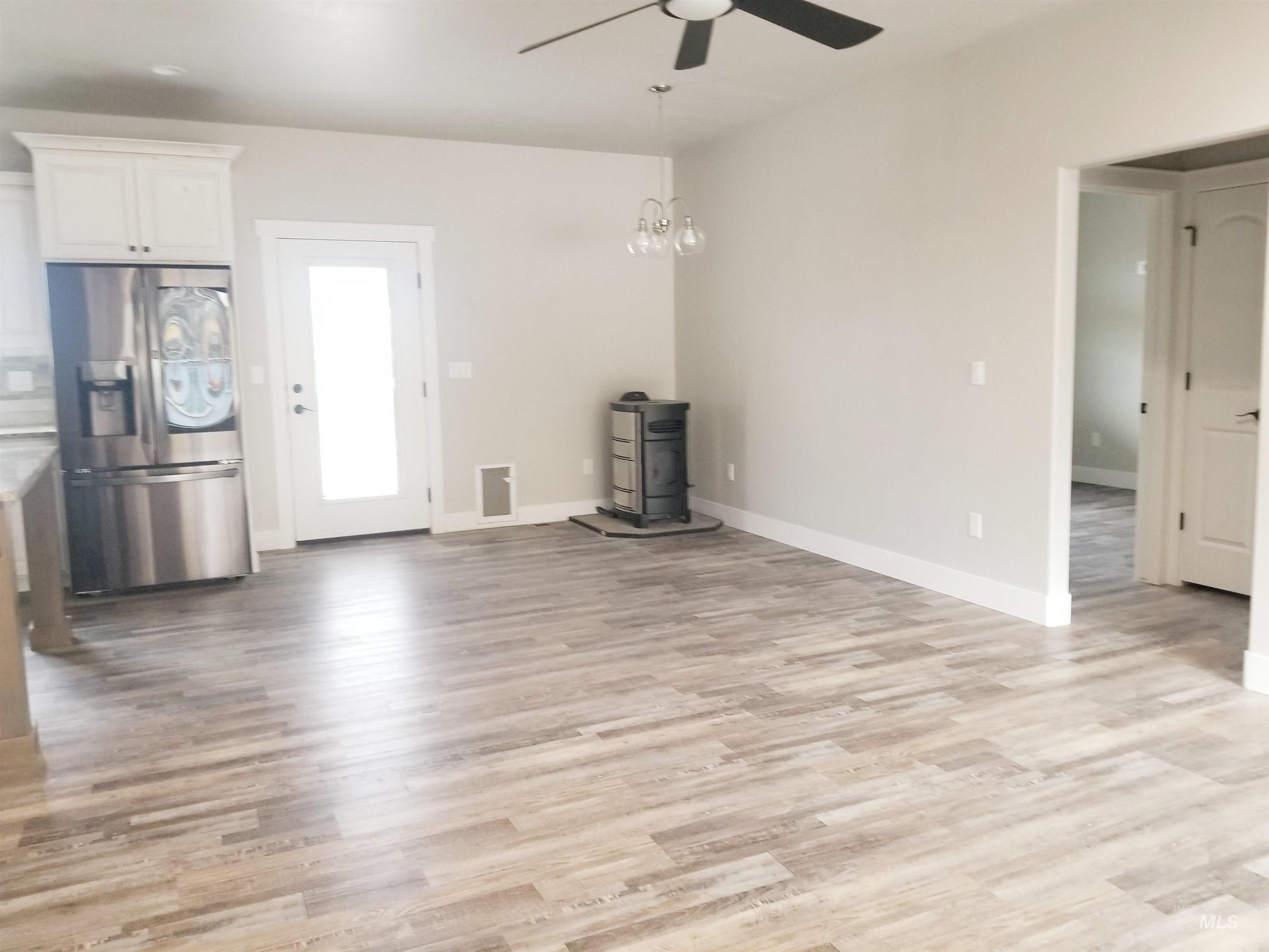 212 Fafnir Drive Kimberly, ID 83341 - Photo 11 of 36 Unfurnished living room featuring ceiling fan, light wood-style flooring, and a chandelier