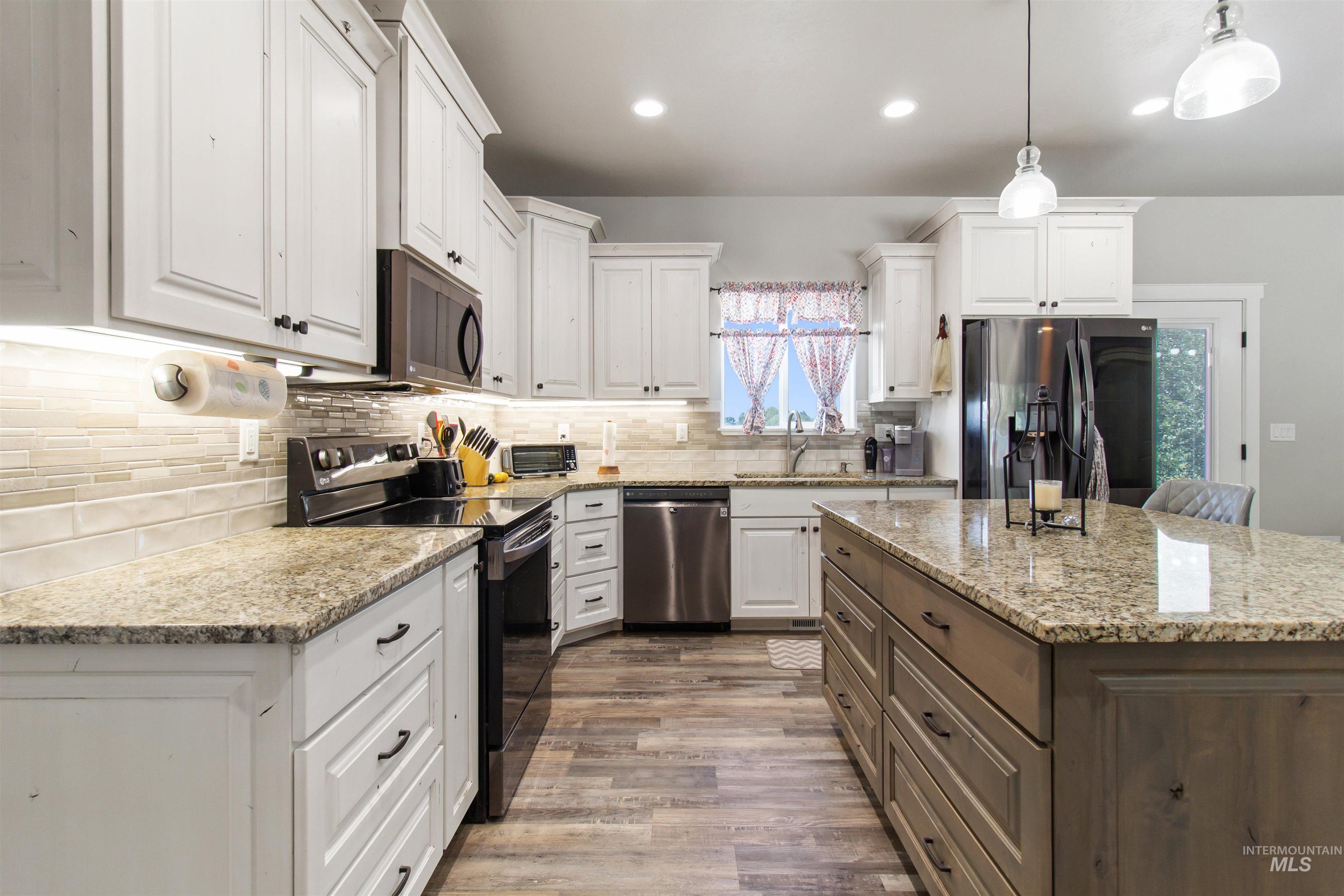 212 Fafnir Drive Kimberly, ID 83341 - Photo 12 of 36 Kitchen with stainless steel appliances, light stone countertops, white cabinetry, pendant lighting, and decorative backsplash