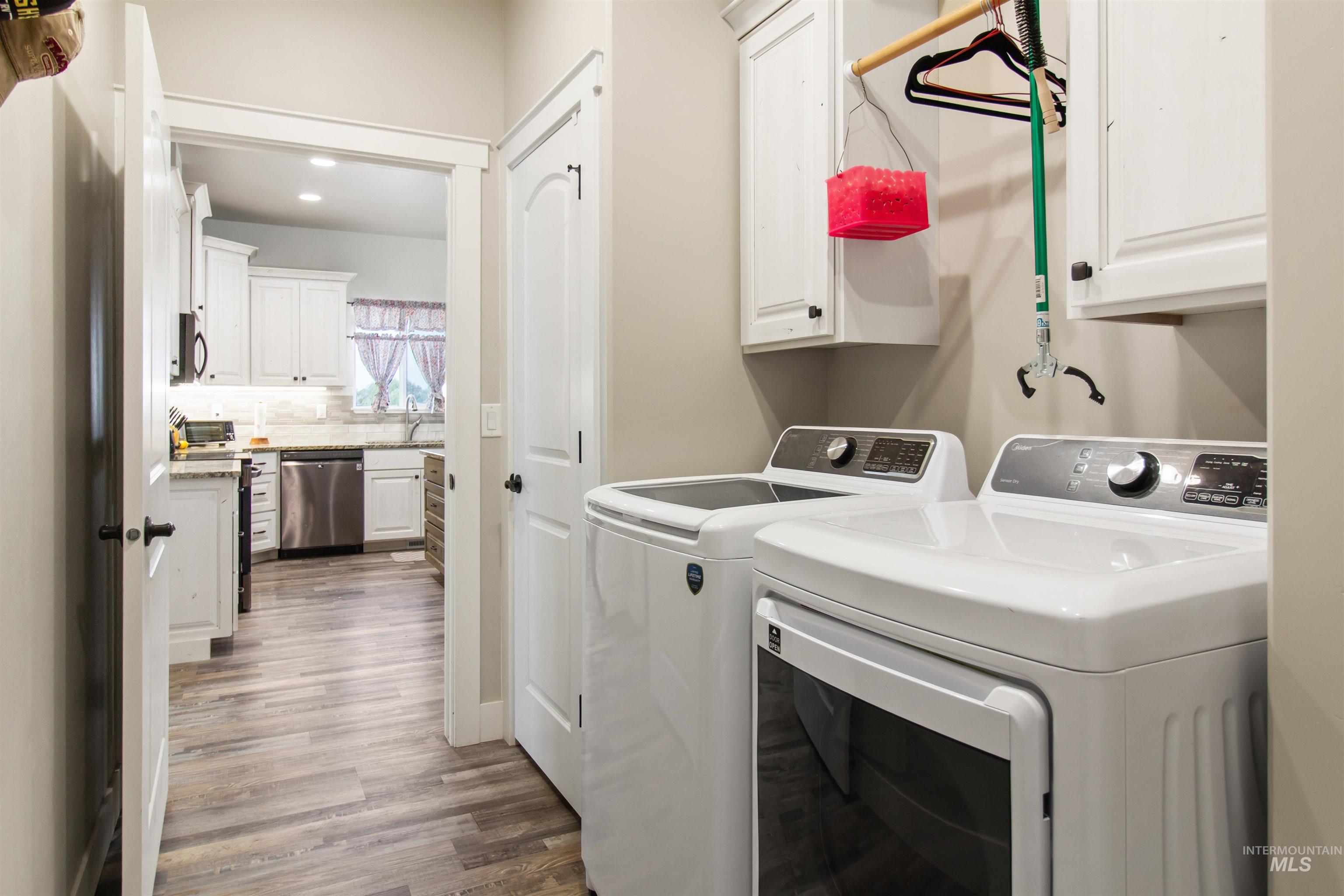 212 Fafnir Drive Kimberly, ID 83341 - Photo 24 of 36 Laundry room featuring washing machine and dryer, wood finished floors, cabinet space, and recessed lighting