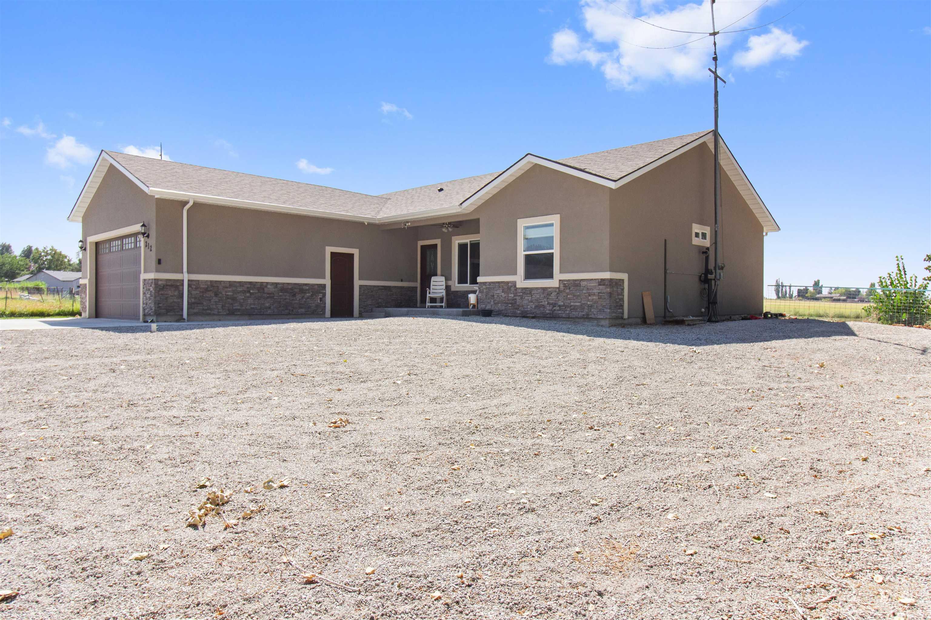 212 Fafnir Drive Kimberly, ID 83341 - Photo 25 of 36 Rear view of property with stone siding, stucco siding, a garage, and driveway