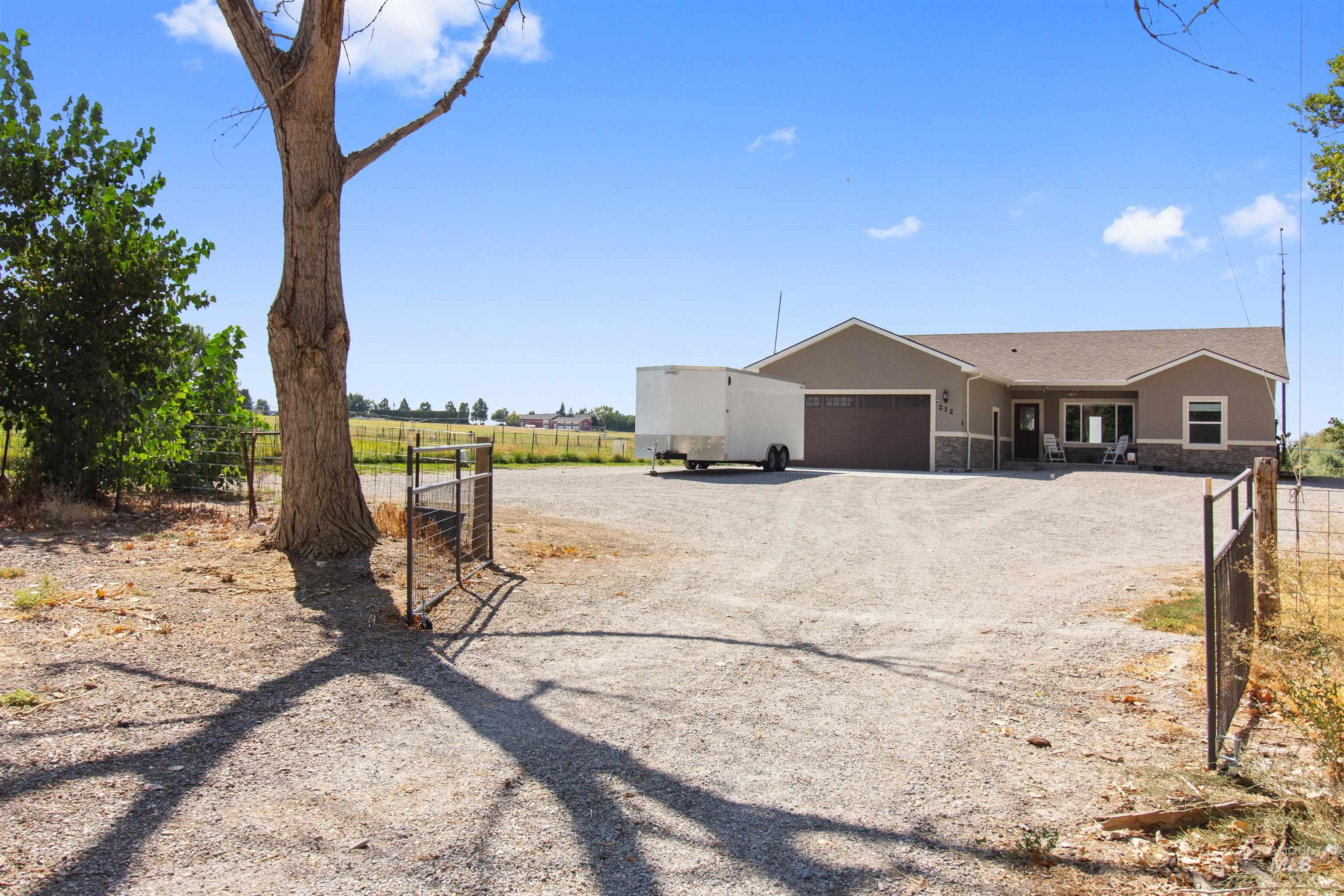 212 Fafnir Drive Kimberly, ID 83341 - Photo 29 of 36 View of front of house with gravel driveway, stucco siding, an attached garage, a view of rural / pastoral area, and stone siding