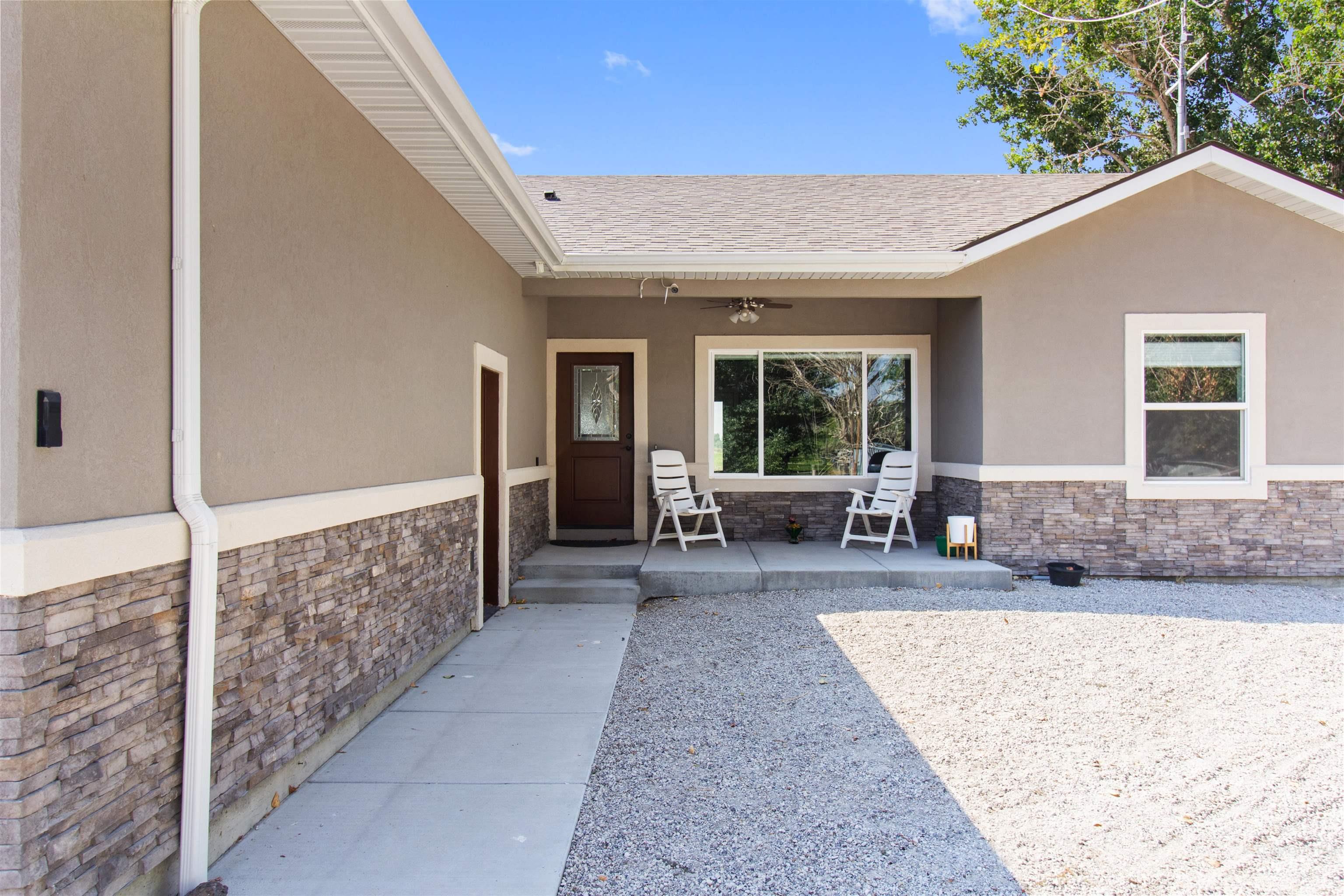212 Fafnir Drive Kimberly, ID 83341 - Photo 5 of 36 Doorway to property with stone siding, stucco siding, ceiling fan, and a porch