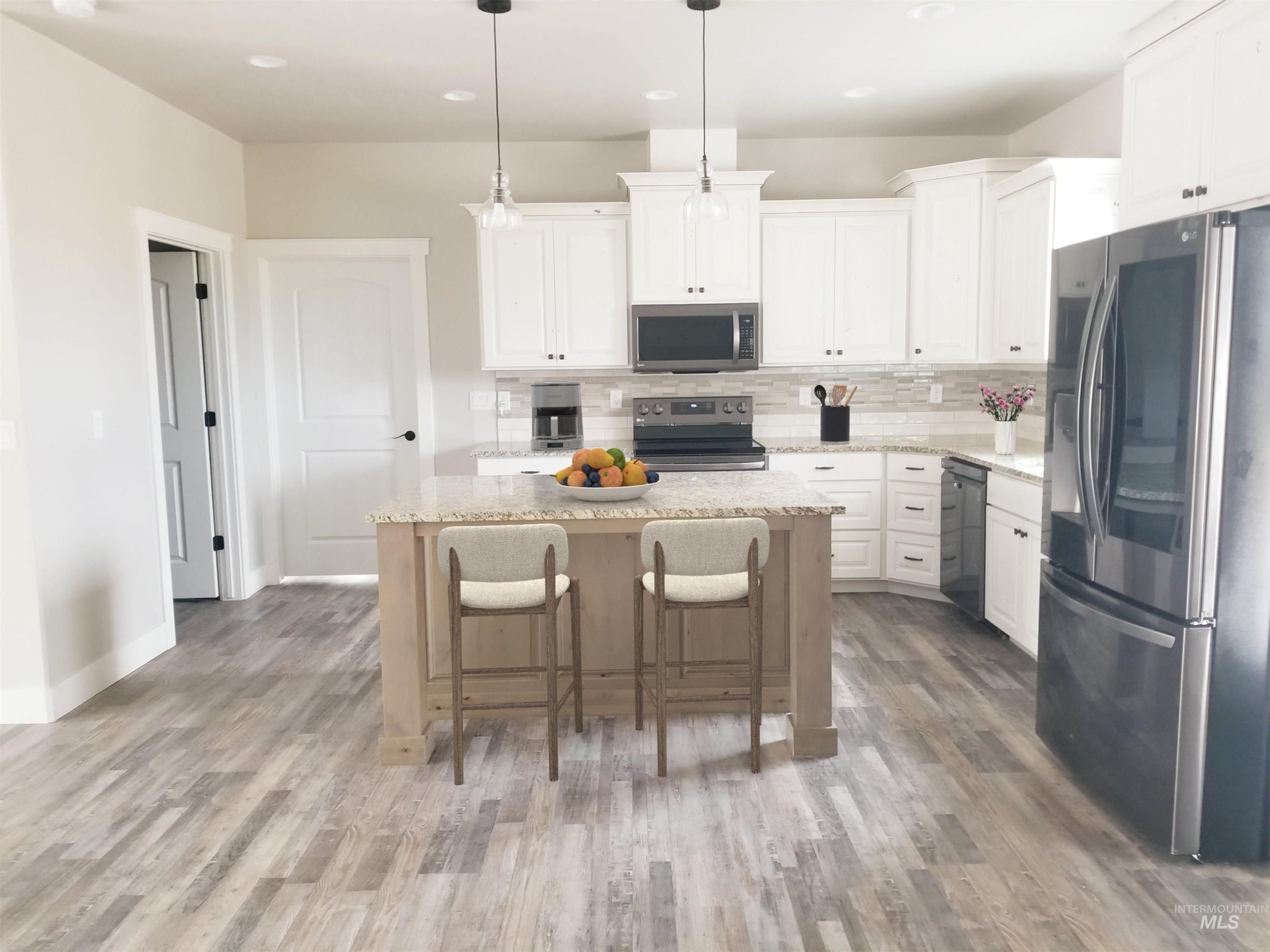 212 Fafnir Drive Kimberly, ID 83341 - Photo 8 of 36 Kitchen featuring stainless steel appliances, decorative backsplash, a kitchen breakfast bar, a kitchen island, and recessed lighting
