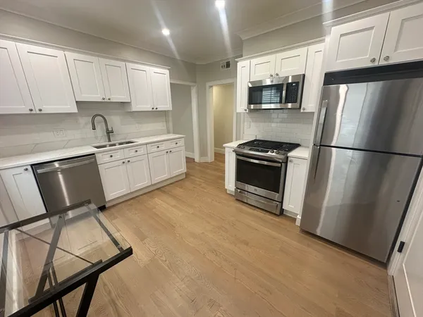 a kitchen with granite countertop a refrigerator stove and microwave