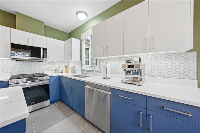 a kitchen with stainless steel appliances granite countertop a sink a stove and a microwave