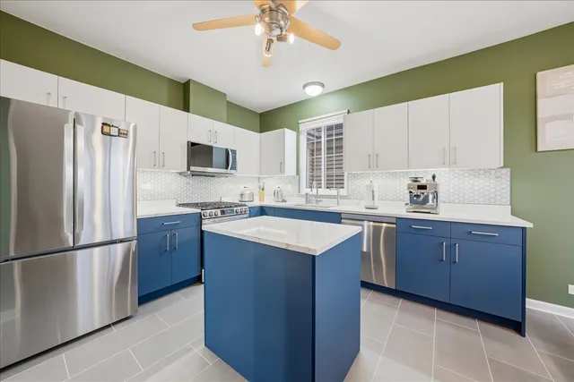 a kitchen with stainless steel appliances granite countertop a refrigerator a sink dishwasher a stove top oven a refrigerator and cabinets