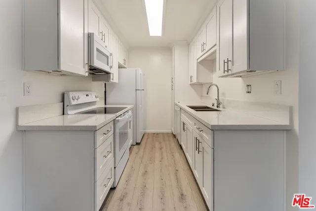 a kitchen with stainless steel appliances a sink stove and cabinets