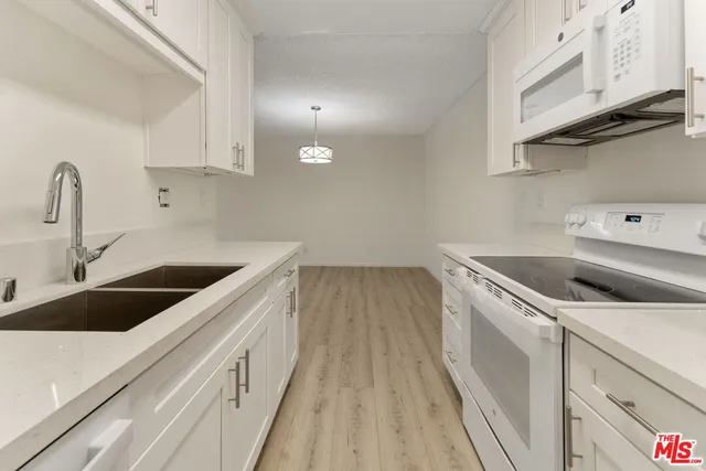 a kitchen with a sink and a stove top oven