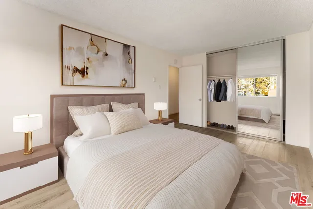 a bedroom with a bed and a painting on the wall