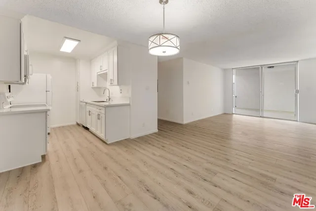 a view of a kitchen with wooden floor and a chandelier
