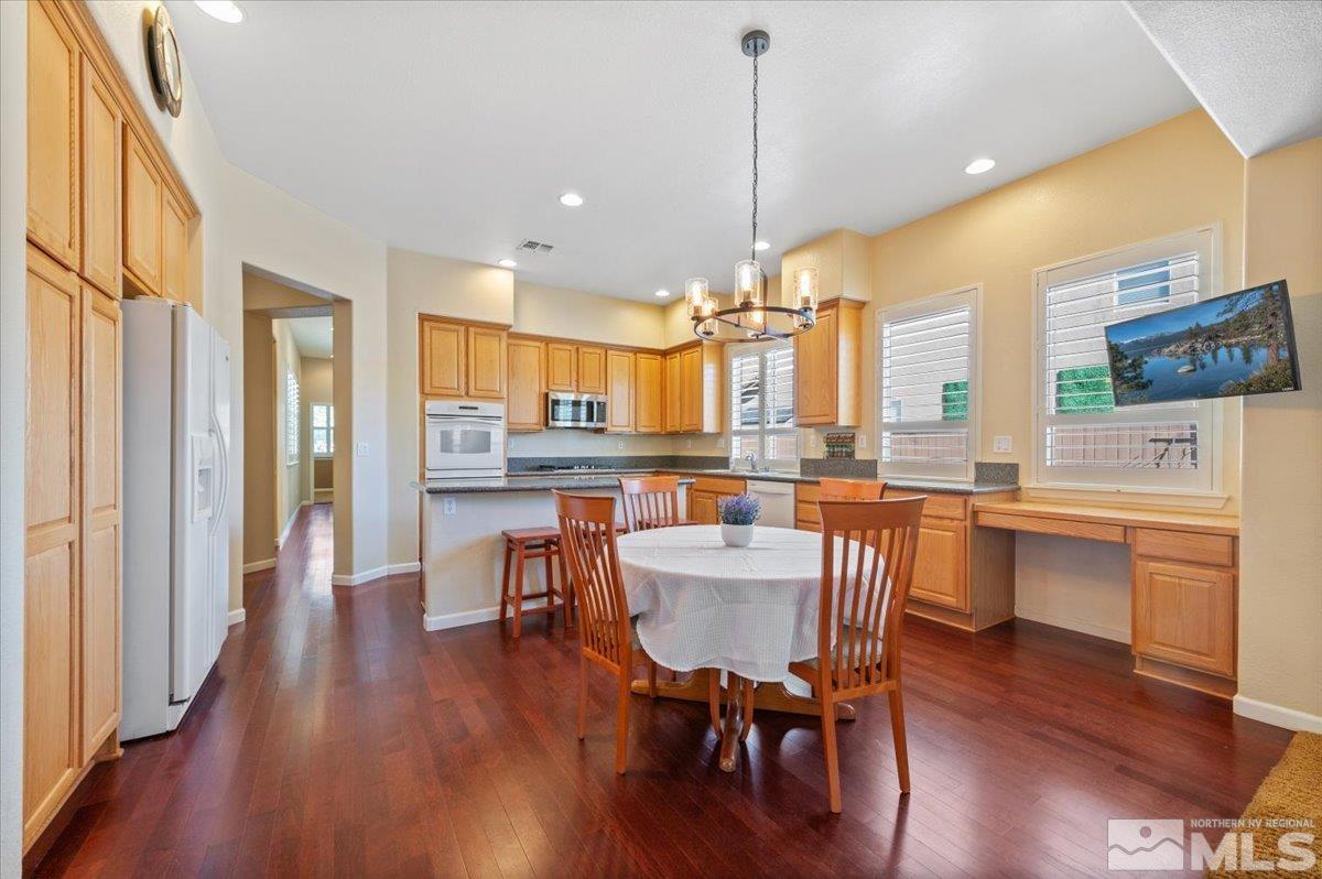 10665 Autumn Walk Lane Reno, NV 89521 - Photo 11 of 35 a kitchen with stainless steel appliances a dining table chairs stove and cabinets