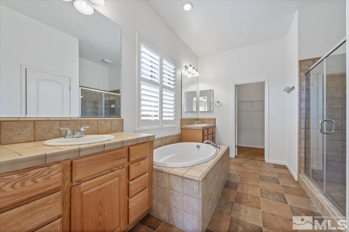 10665 Autumn Walk Lane Reno, NV 89521 - Photo 17 of 35 a spacious bathroom with a granite countertop sink a toilet a mirror and shower
