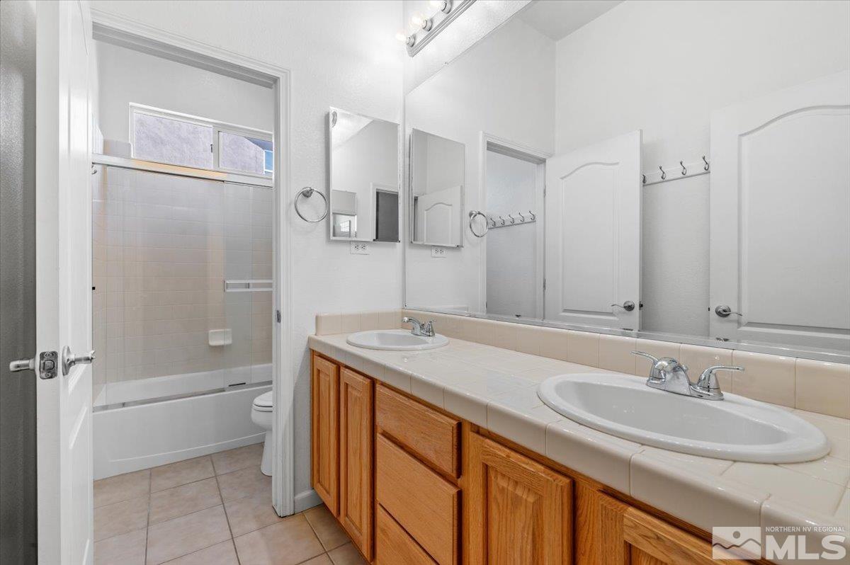 10665 Autumn Walk Lane Reno, NV 89521 - Photo 22 of 35 a bathroom with a sink double vanity granite tub shower and a mirror