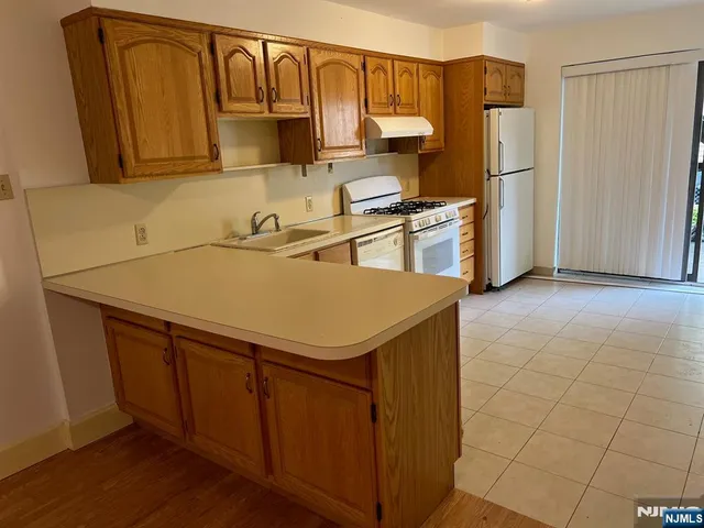 a kitchen with stainless steel appliances a refrigerator and a stove top oven