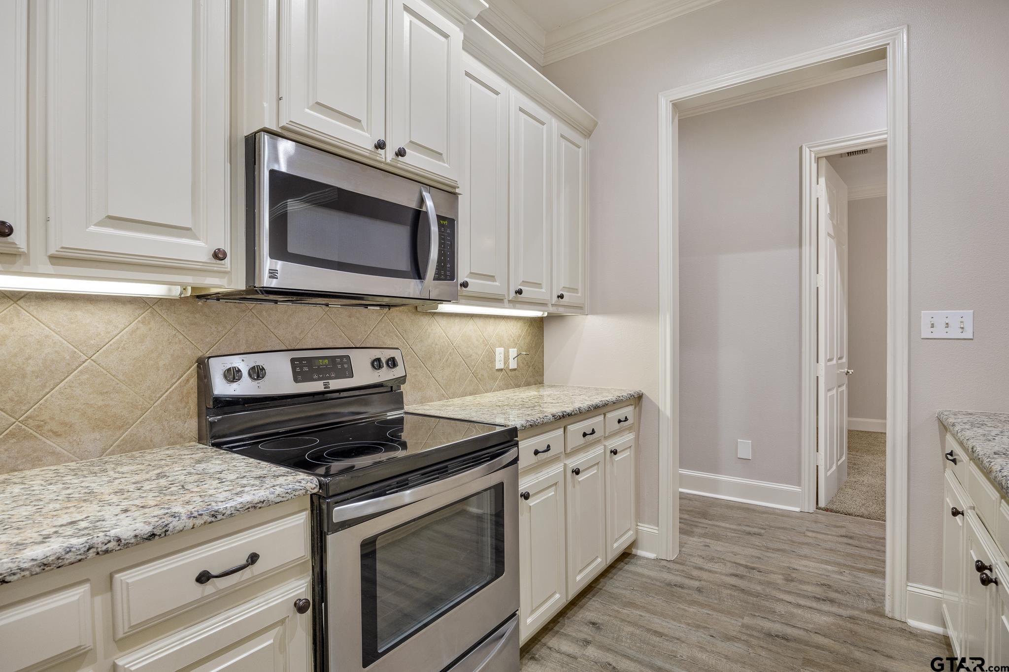 2431 Homestead Lane Tyler, TX 75701 - Photo 12 of 26 a kitchen with stainless steel appliances granite countertop a stove microwave and sink