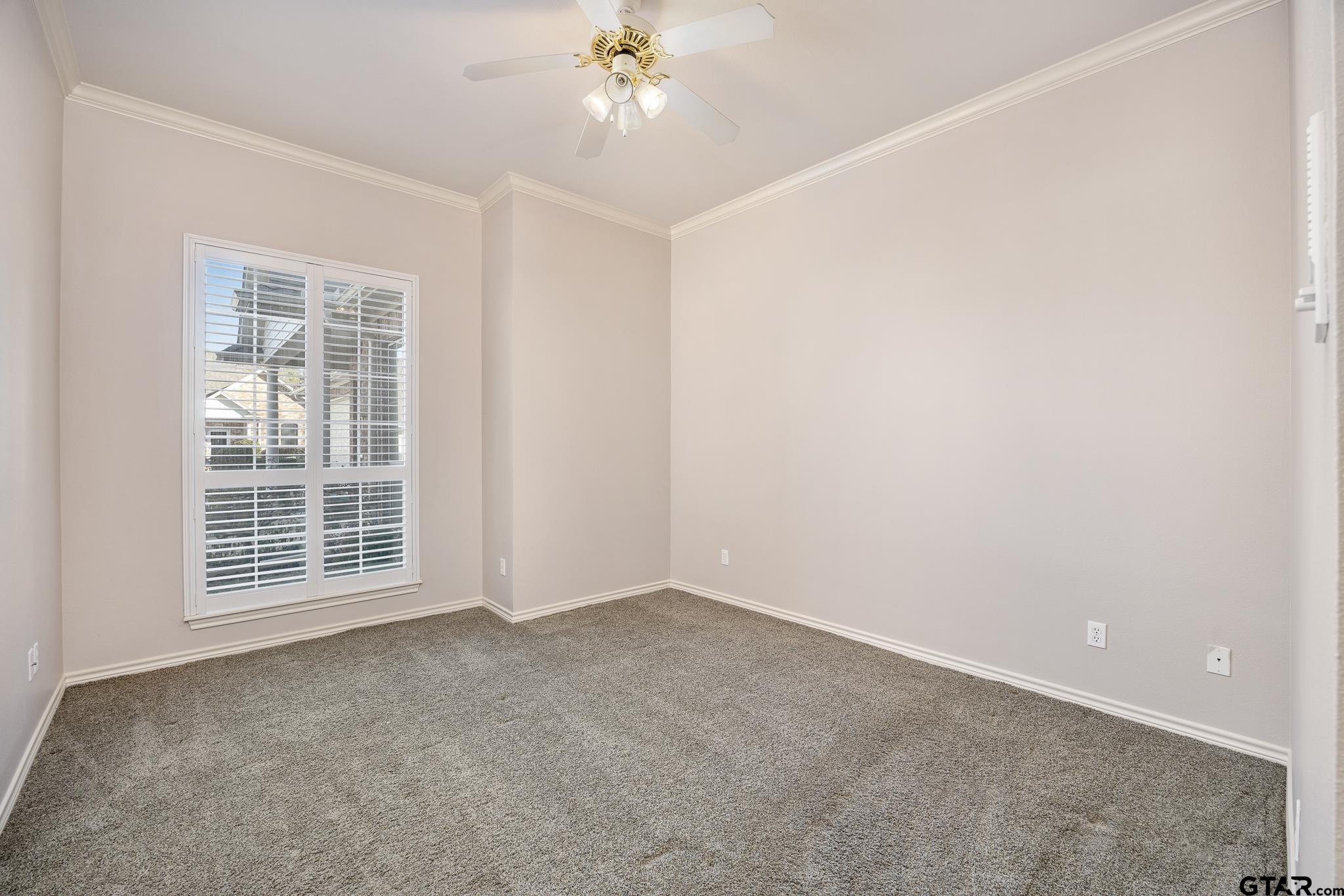2431 Homestead Lane Tyler, TX 75701 - Photo 6 of 26 an empty room with a chandelier fan and windows