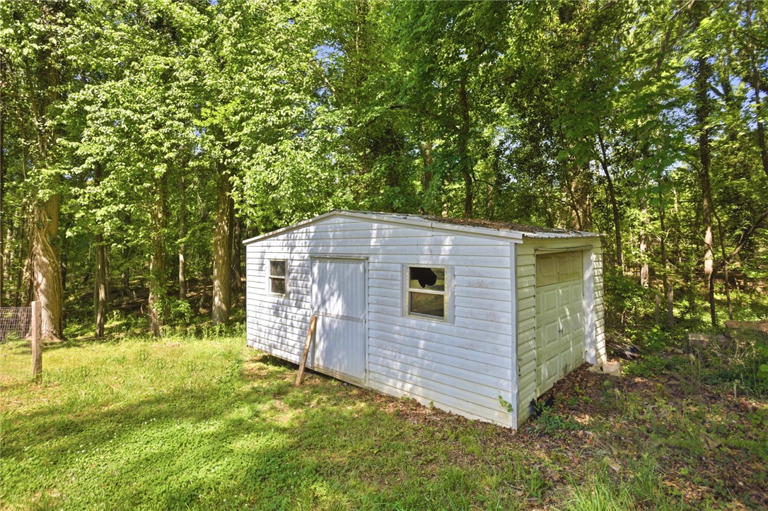 311 Cumberland Way Anderson, SC 29621 - Photo 43 of 44 A quaint storage shed offers functional utility amidst a verdant, mature treeline.