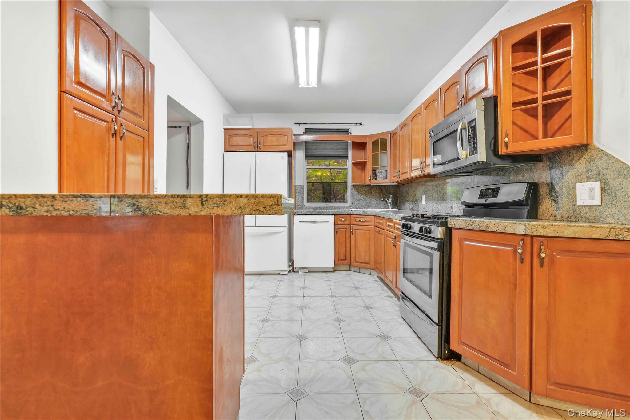 84-39 Lefferts Boulevard, Unit 1 Queens, NY 11415 - Photo 13 of 42 a kitchen with stainless steel appliances granite countertop a stove a sink and dishwasher