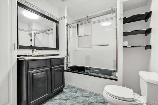 a bathroom with a double vanity sink toilet and shower