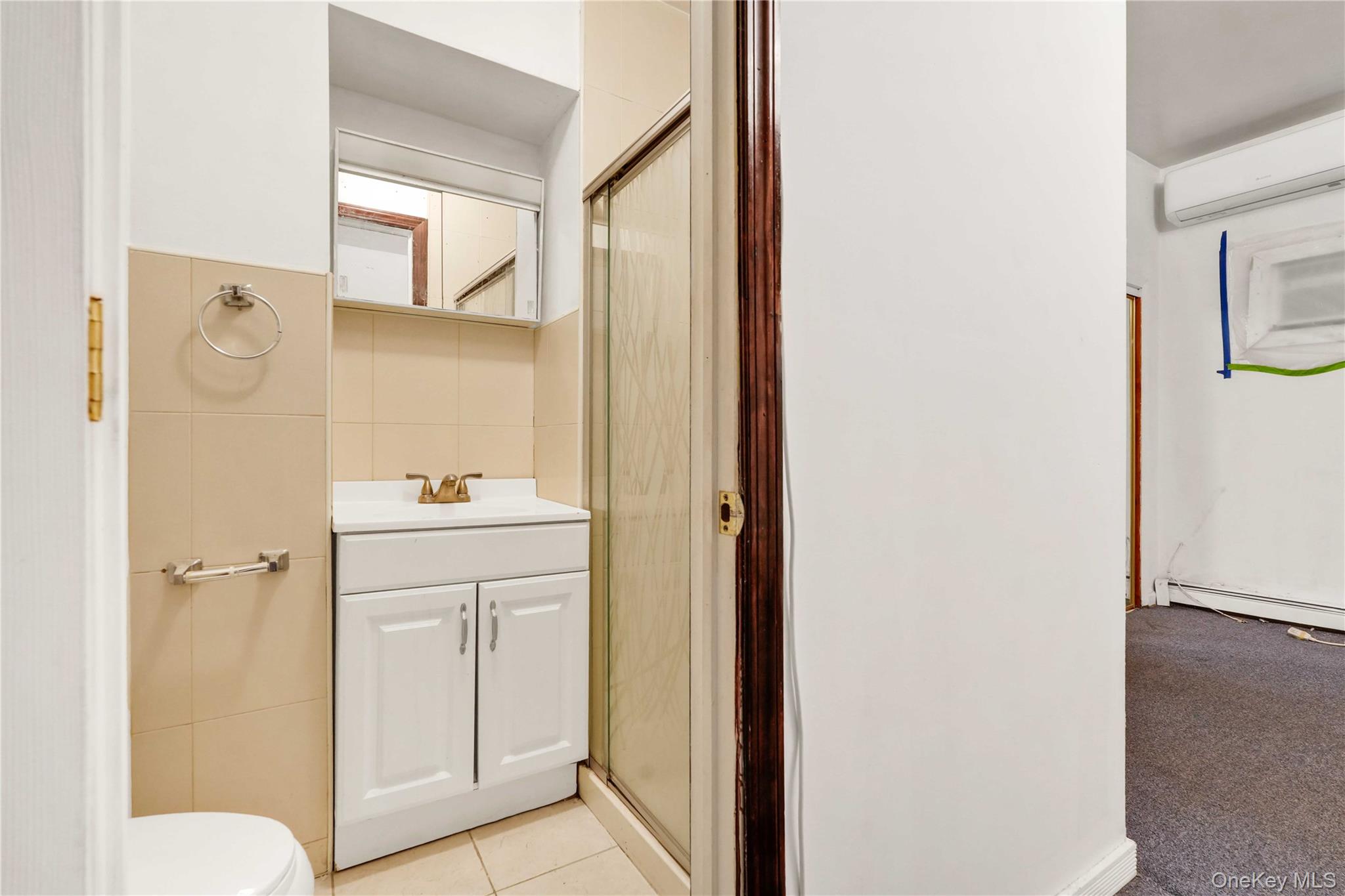 84-39 Lefferts Boulevard, Unit 1 Queens, NY 11415 - Photo 30 of 42 a bathroom with a sink and mirror with toilet