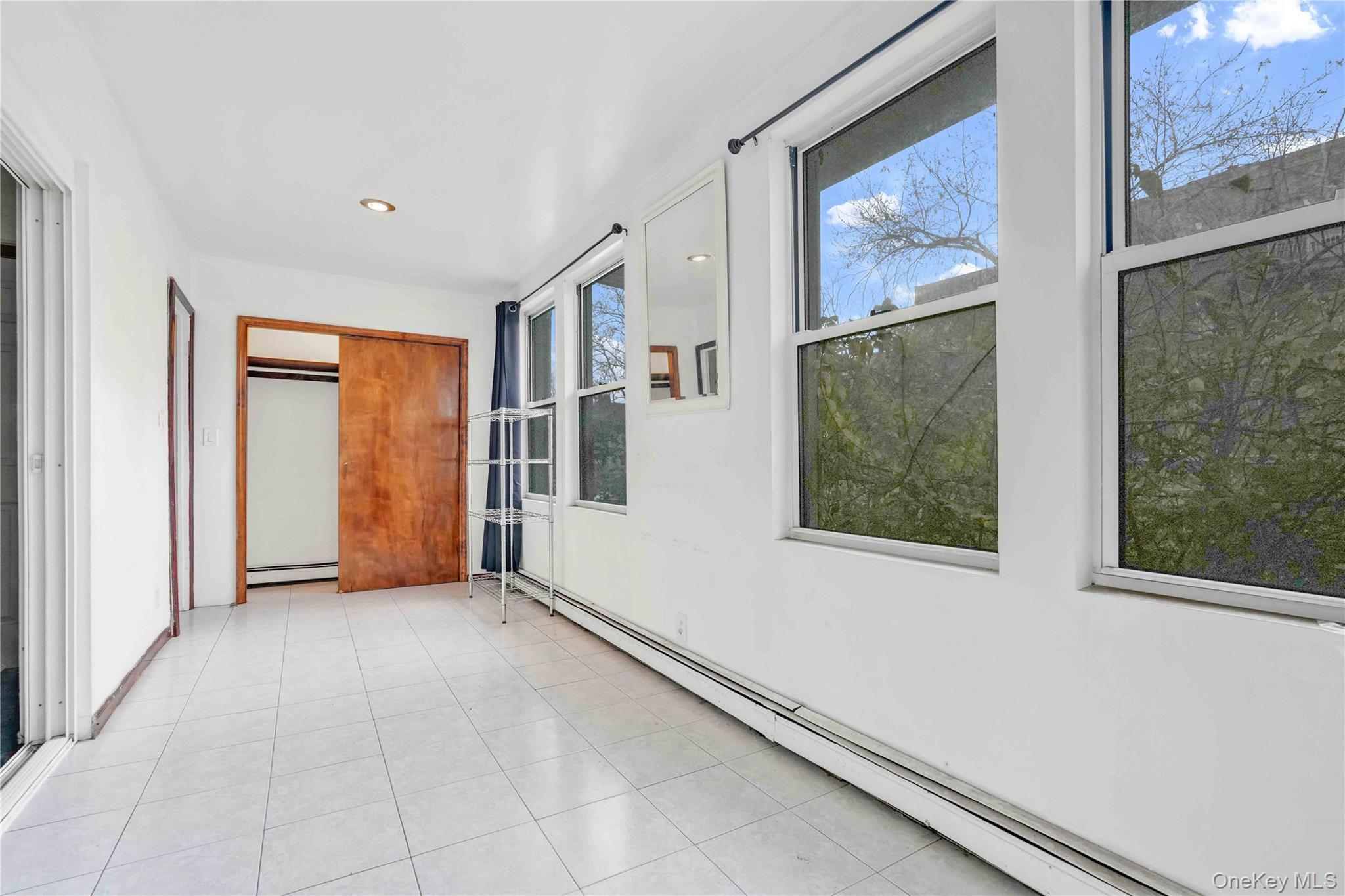84-39 Lefferts Boulevard, Unit 1 Queens, NY 11415 - Photo 9 of 42 an empty room with windows