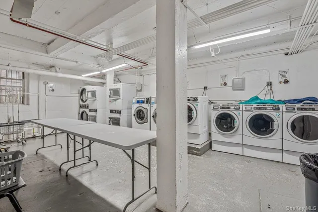 a utility room with dryer washer and empty racks