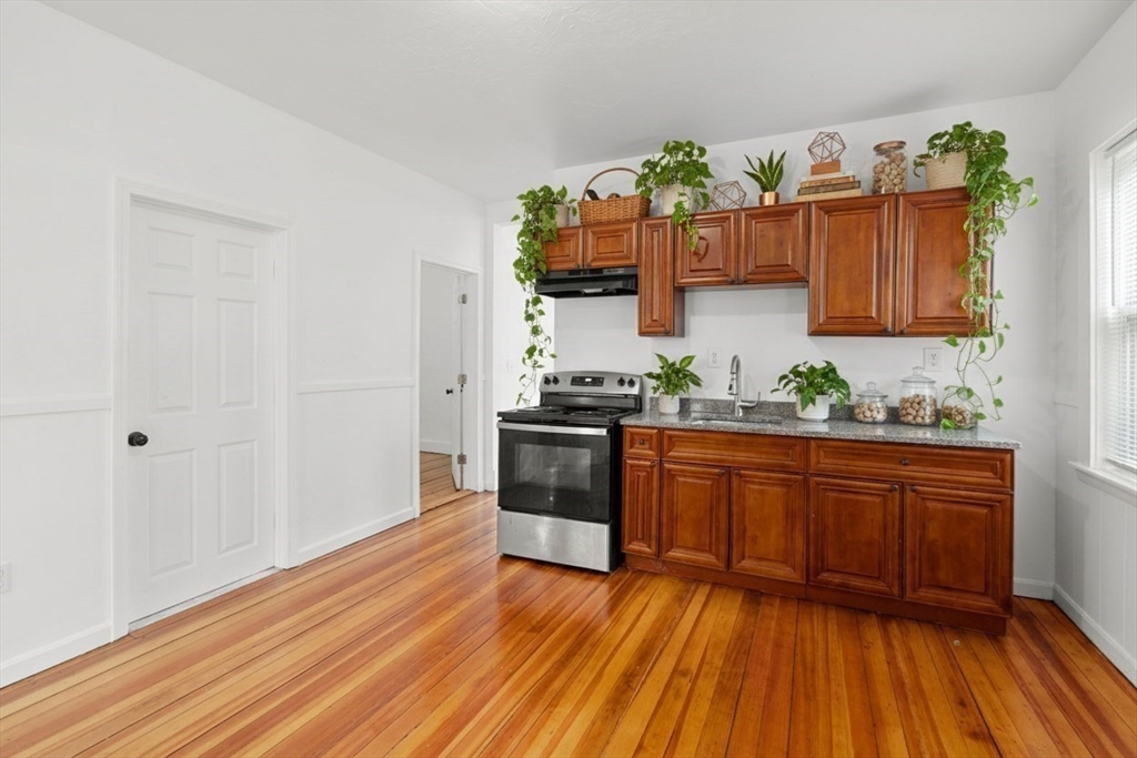 170 Allston Street, Unit 1 Providence, RI 02908 - Photo 5 of 12 a kitchen with granite countertop wooden floors stainless steel appliances and cabinets