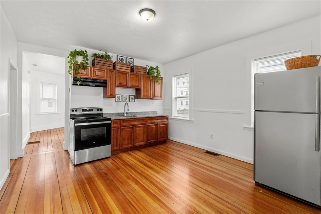 170 Allston Street, Unit 1 Providence, RI 02908 - Photo 6 of 12 a kitchen with stainless steel appliances a refrigerator and a stove top oven