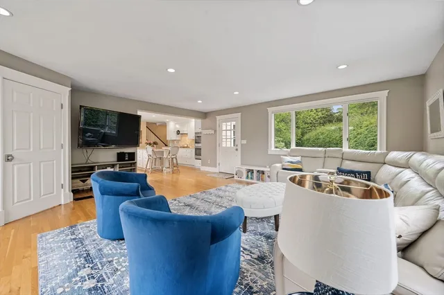 a living room with furniture flat screen tv and a large window