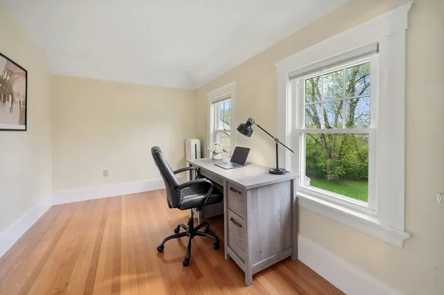 a view of a workspace with furniture and a window
