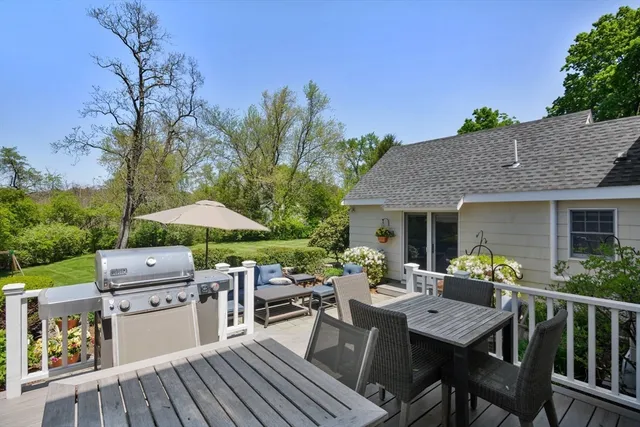 a view of a patio with table and chairs under an umbrella with potted plants