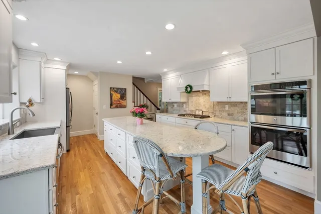 a large kitchen with granite countertop lots of counter top space and stainless steel appliances