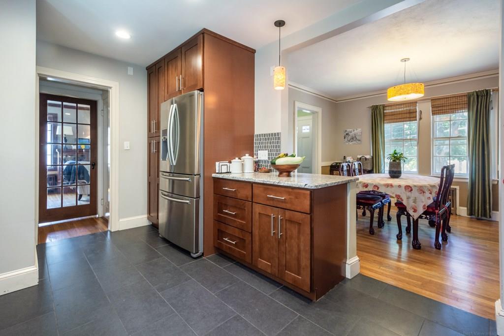 62 Theodore Road Newton, MA 02459 - Photo 9 of 29 a room with stainless steel appliances kitchen island granite countertop a refrigerator a sink a dining table and chairs