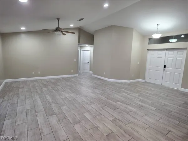 a view of an empty room with wooden floor