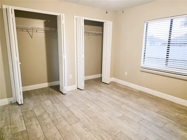 an empty room with window and a bathroom