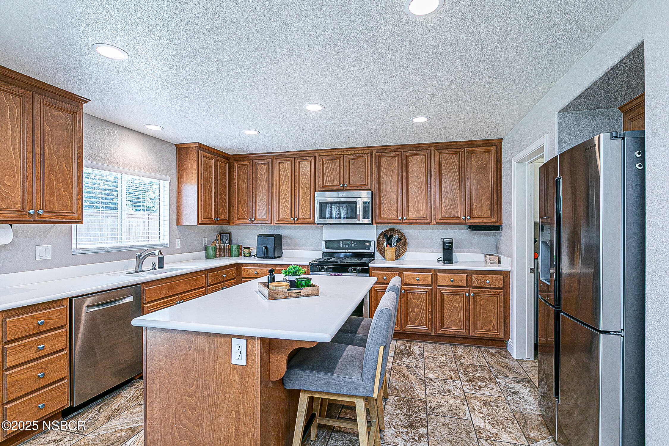 1104 Honda Way Lompoc, CA 93436 - Photo 18 of 36 a kitchen with stainless steel appliances granite countertop a refrigerator a sink dishwasher a stove and white countertops with wooden floor
