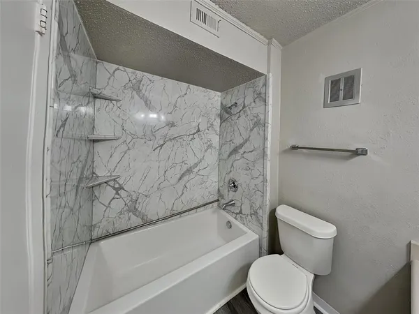 a white toilet sitting next to a bath tub and a shower