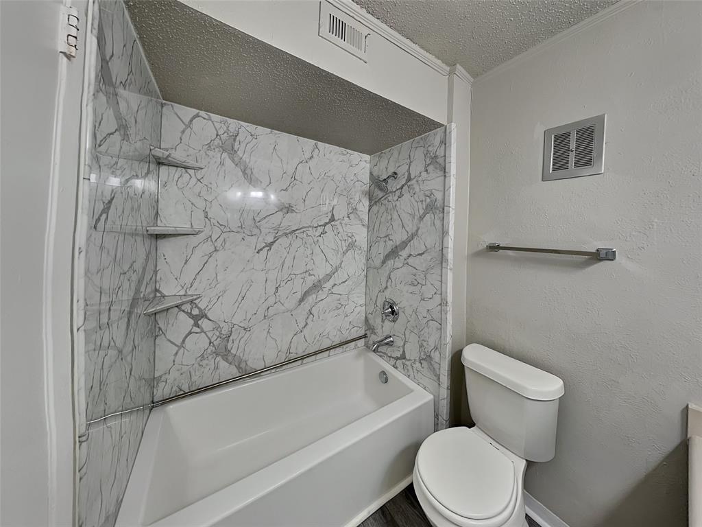 5618 Boca Raton Boulevard, Unit 143 Fort Worth, TX 76112 - Photo 7 of 10 a white toilet sitting next to a bath tub and a shower