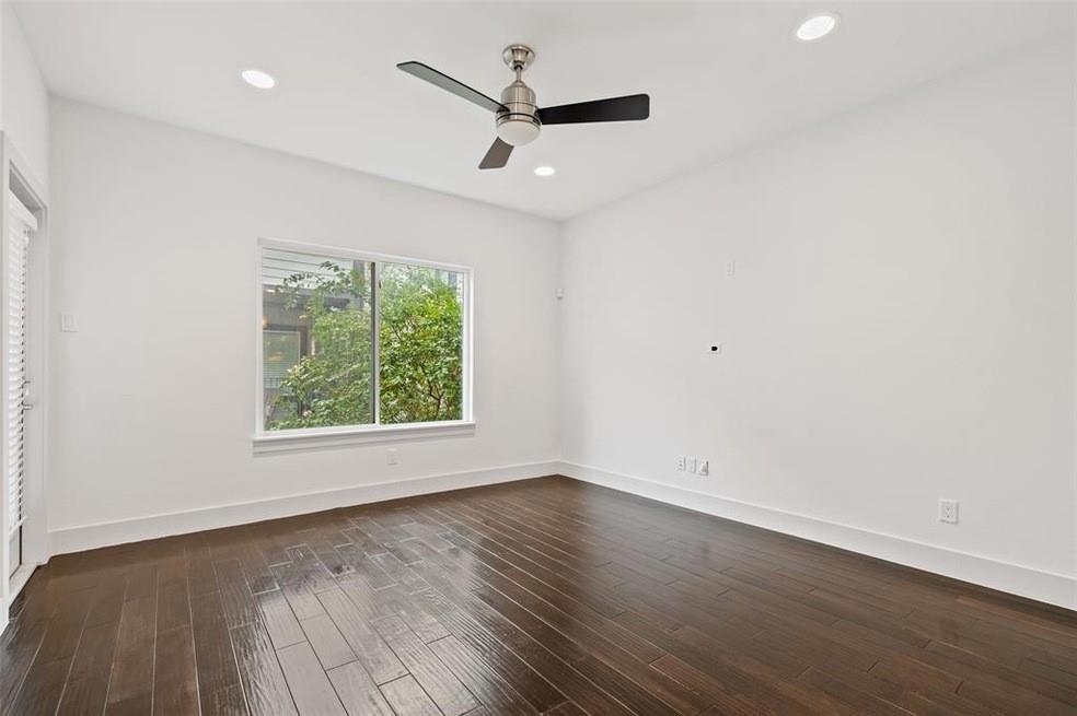 5924 Hudson Street, Unit F Dallas, TX 75206 - Photo 8 of 25 an empty room with wooden floor and windows