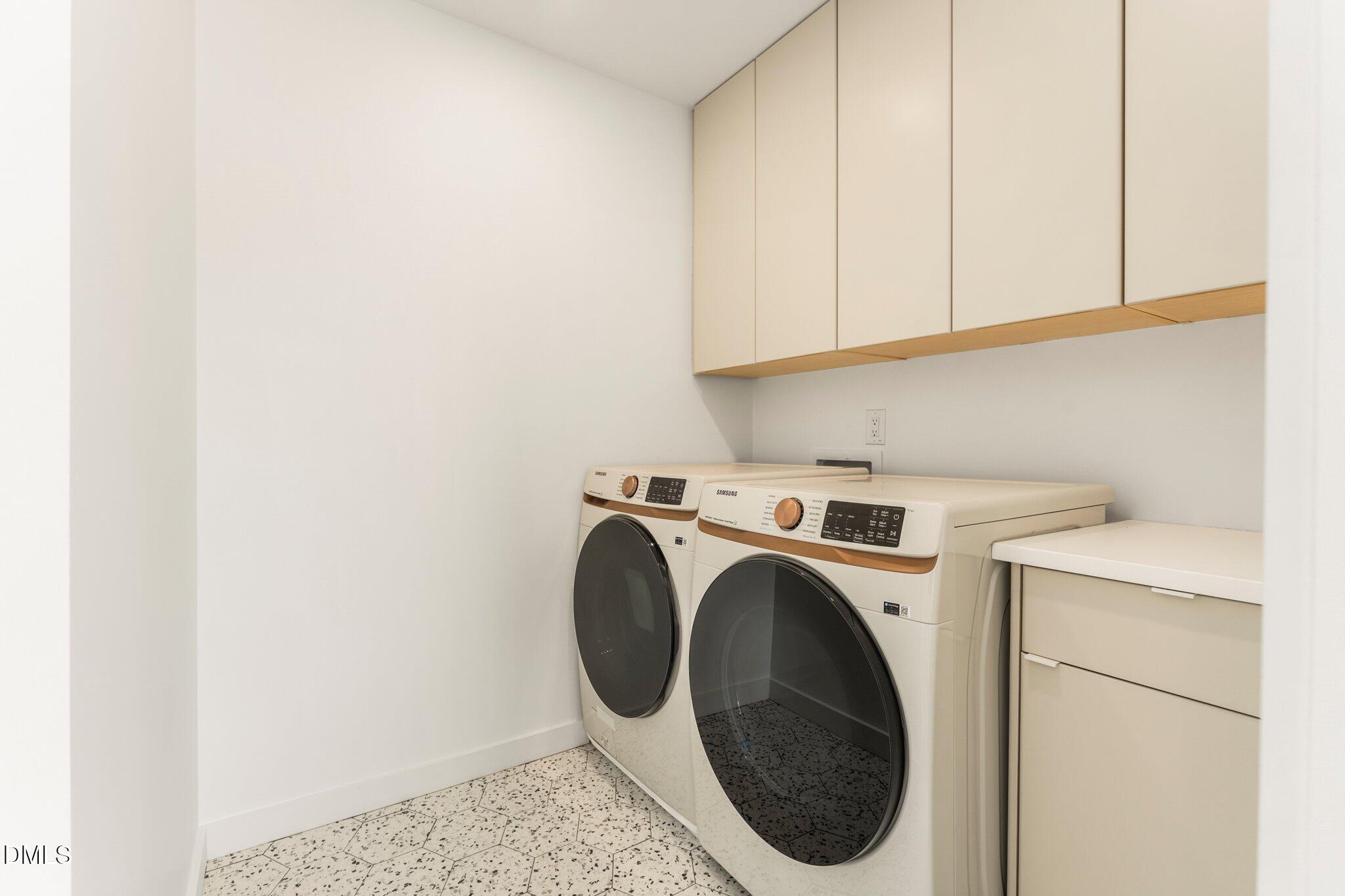 409 Alston Street, Unit 101 Raleigh, NC 27601 - Photo 15 of 39 Laundry room with custom cabinetry, table top for folding laundry, matching front load Samsung washer and dryer unit set