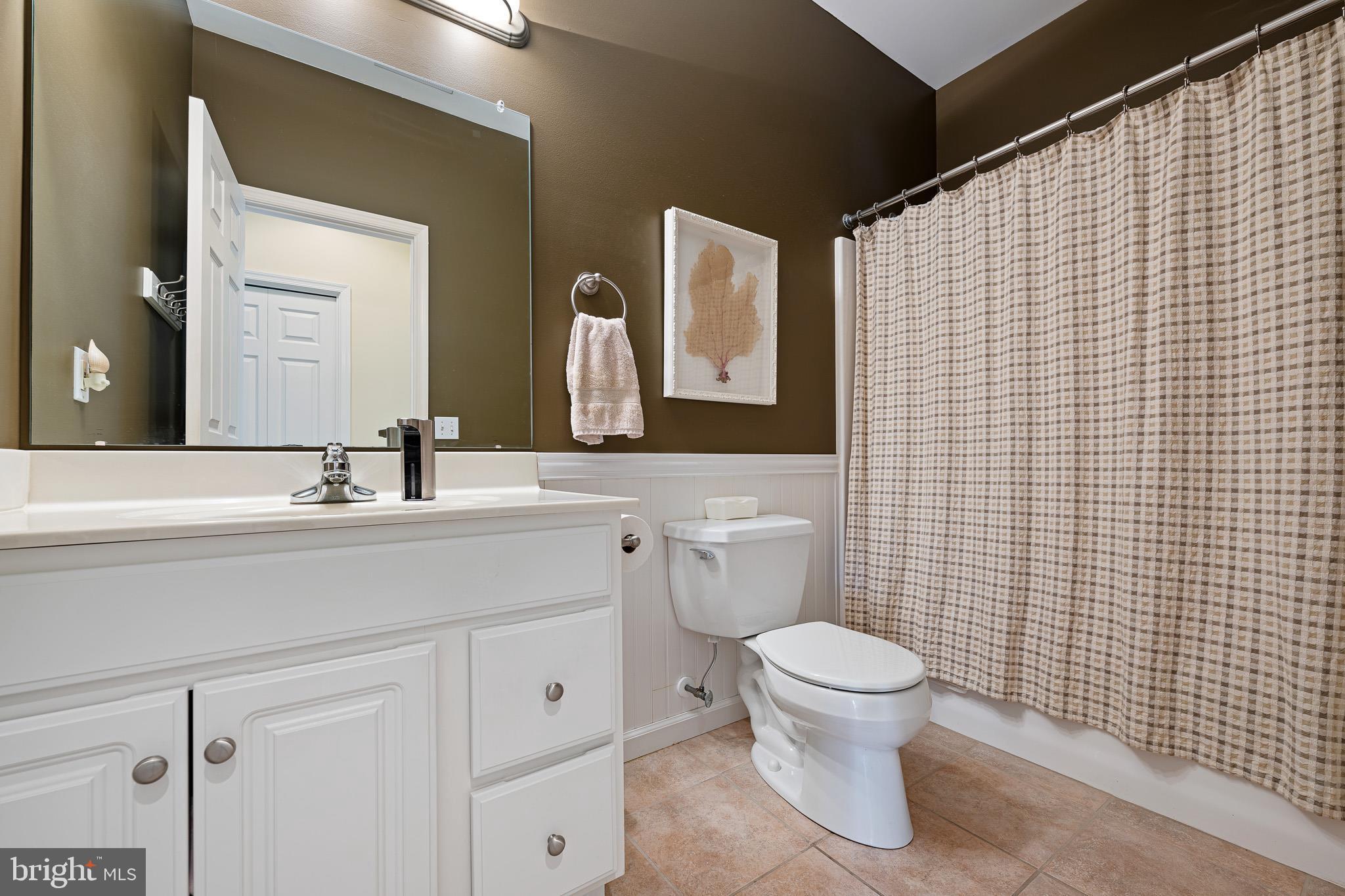 38744 Skipjack Village Road, Unit 14 Bethany Beach, DE 19930 - Photo 18 of 70 a bathroom with a toilet sink vanity and mirror
