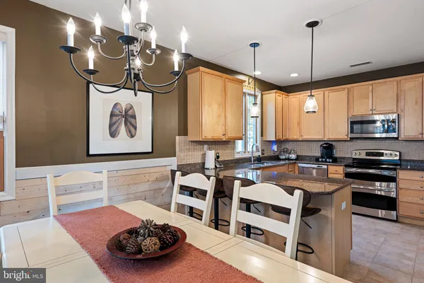 a kitchen with granite countertop a sink stainless steel appliances and cabinets