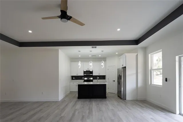 a large kitchen with a refrigerator a window and a counter top space