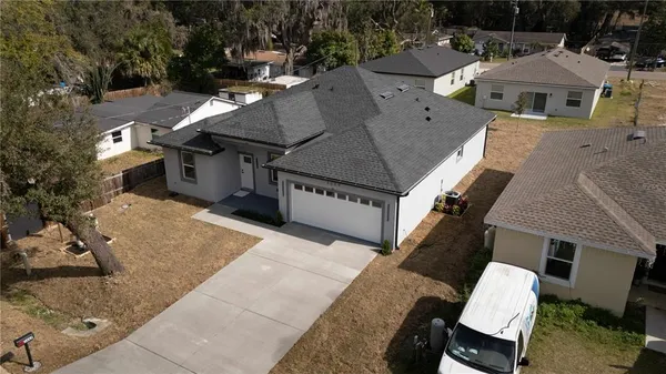 aerial view of a house with a yard and tree s