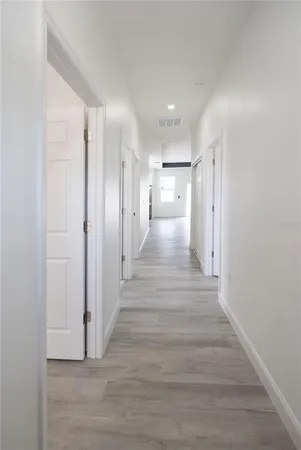 a view of a hallway with wooden floor