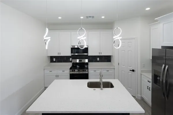 a kitchen with stainless steel appliances a refrigerator and stove