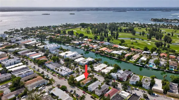 an aerial view of a city with lots of residential buildings ocean and mountain view in back